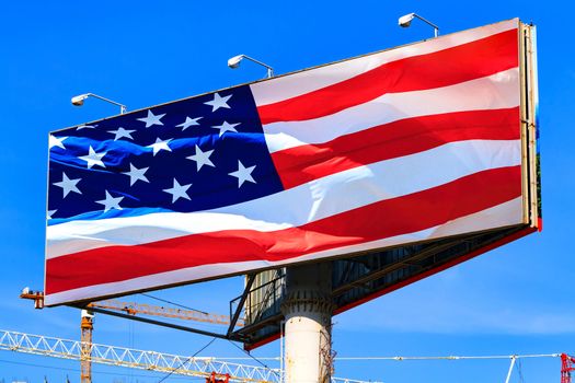 Large billboard with the USA american flag with blue sky behind it.