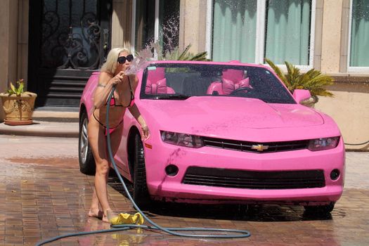 Frenchy Morgan the "Celebrity Big Brother" Star is spotted on a hot day wearing a tiny pink bikini while washing her pink car in Malibu, CA 05-22-17