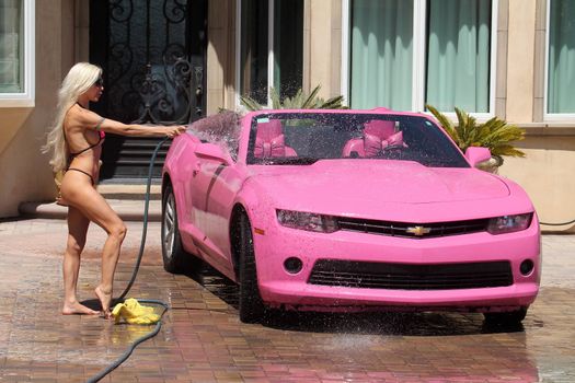 Frenchy Morgan the "Celebrity Big Brother" Star is spotted on a hot day wearing a tiny pink bikini while washing her pink car in Malibu, CA 05-22-17