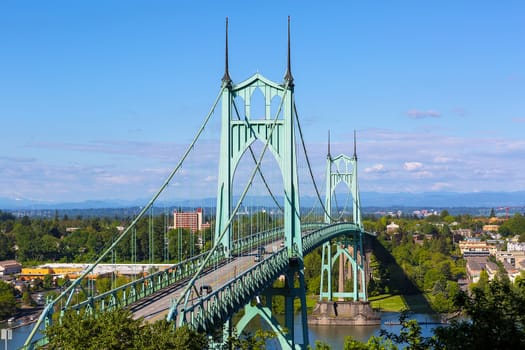 St Johns Bridge over Willamette River and Cathedral Park in Portland Oregon on a blue sky sunny day