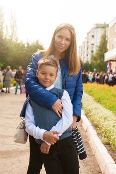 The first time in first class: happy schoolboy with his mother going to the school in first time