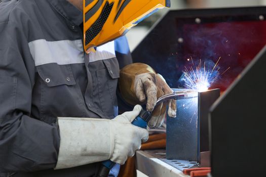 Worker with protective mask welding metal