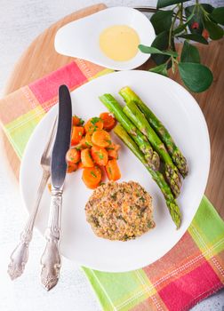 Meat rissole with glazed carrots, asparagus on the plate 