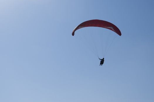 Colorful hang glider in sky over blue sea 