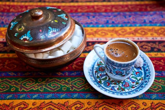 Traditional Turkish Coffee in a ceramic coffee mug on tablecloth traditional texture and pattern