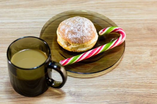 on the plate of a bun and candy along with coffee.