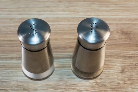 salt and pepper shakers on rustic wooden table.