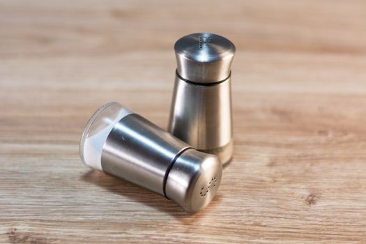 salt and pepper shakers on rustic wooden table.