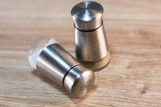 salt and pepper shakers on rustic wooden table.