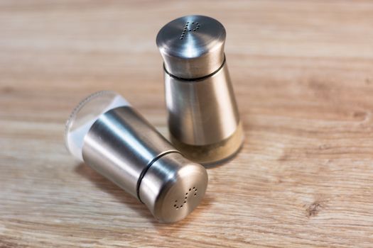 salt and pepper shakers on rustic wooden table.