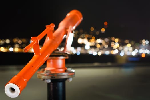 Telescope looking out into defocused lights producing bokeh. shallow depth of field shot. Metaphor of looking for direction  Night time in Wellington, New Zealand.