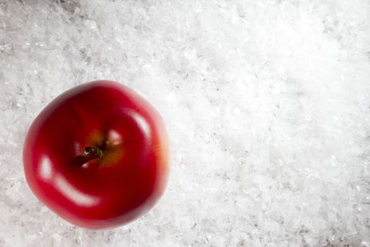 Red apple on white freshly fallen snow