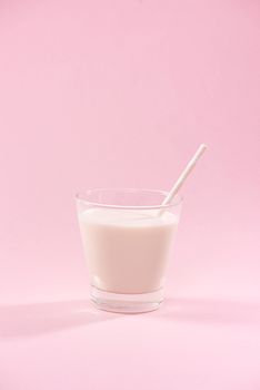 Dairy products. A glass of milk on a pink background.