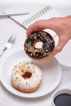 Working desk with dessert and coffee. Cake donuts with a cup of espresso on marble table top. 