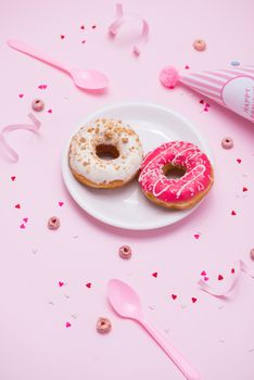 Party. Different colourful sugary round glazed donuts and bottles of drinks on pink background.