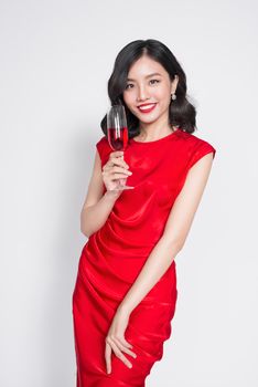 Beautiful asian girl in evening dress smiling holding glass of champagne