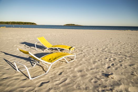 Two deck chairs on sandy beach in Maine, USA