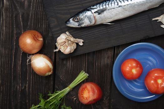 Mackerel and vegetables on a wooden table. Horizonal photo