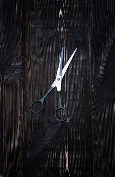 Scissors on a wooden table background