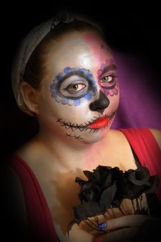 A woman in skull candy makeup for day of the dead celebrations.