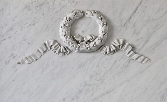 Memorial marble plate with wreath relief as background for text.