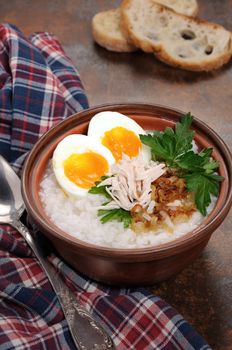 Rice porridge ginger congee with egg, chicken, crispy shallots and parsley