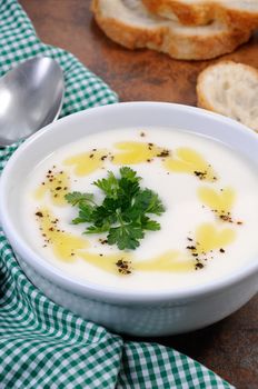 A bowl of white bean puree soup with spicy butter and spices, herb