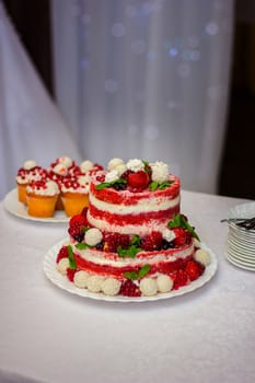 wedding cake on a table with a wild strawberry and berries