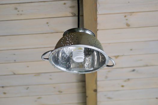Hanging light in the form of a paste strainer