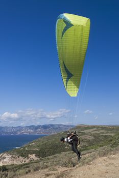 Colorful hang glider in sky over blue sea 