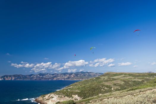 Colorful hang glider in sky over blue sea 