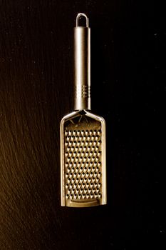 Metallic shiny grater on a black background