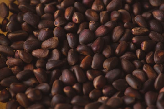 Pine nuts in shells of ciberian cedar as a background. Macro.