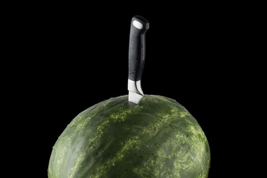 isolated Riped watermelon with knife and black background.