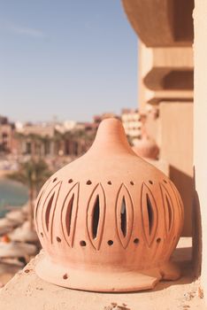 street lamp on the balcony at sunny day with beach and umbrellas, sunbeds, sea as a background.