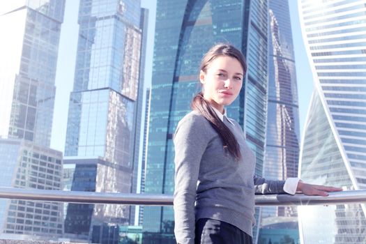 Young beautiful businesswoman outdoors at skyscraper background