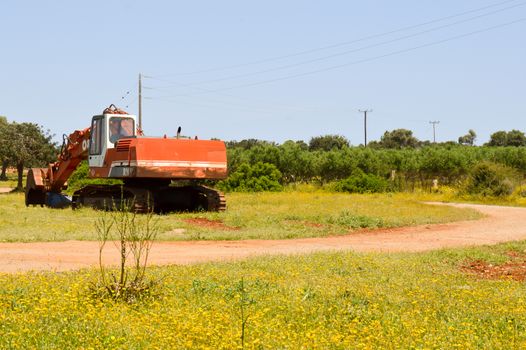 Resting excavator among the daisies in the Crete countryside