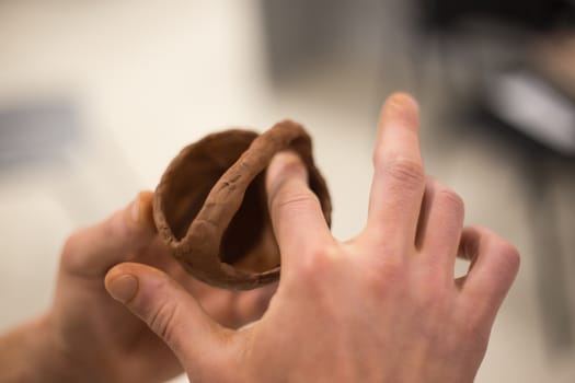 Female hands work with clay