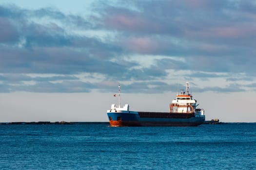 Blue bulk carrier sailing in still water