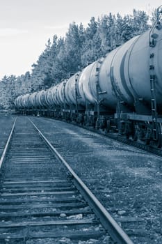 Tank wagons with oil. Freight train in forest