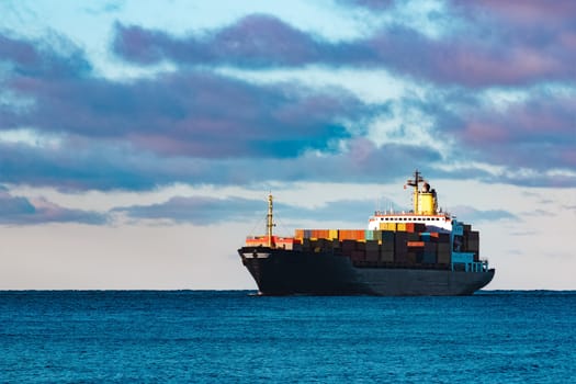 Modern black container ship moving from Baltic sea