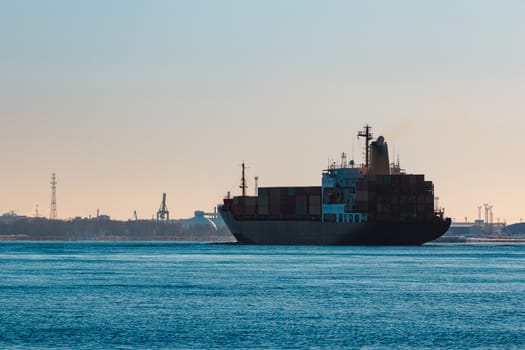 Modern black container ship moving from Baltic sea