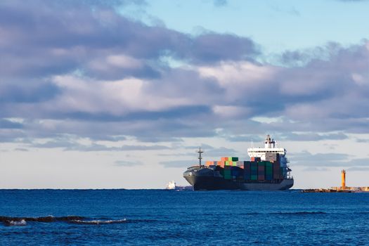 Modern grey container ship moving in still water