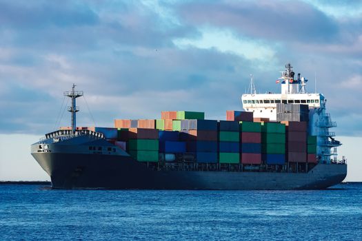 Modern grey container ship moving in still water