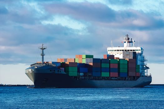 Modern grey container ship moving in still water