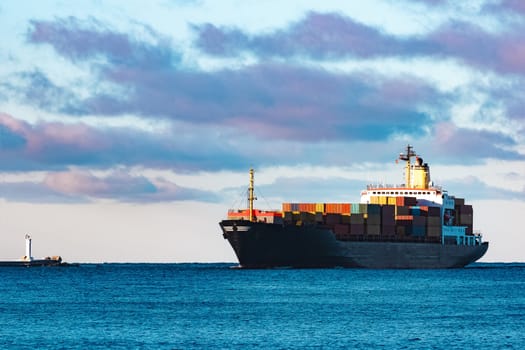 Modern black container ship moving from Baltic sea