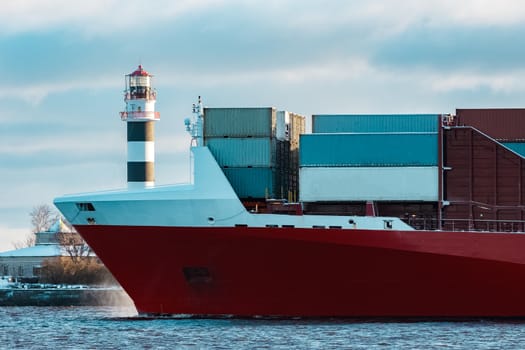 Full red container ship moving in still water