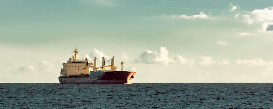 Red cargo ship (bulk carrier) sailing in open sea