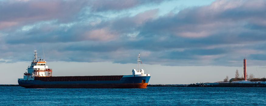 Blue bulk carrier sailing in still water