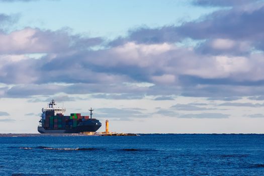 Modern grey container ship moving in still water